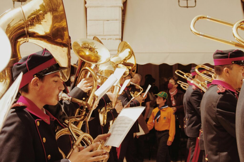Energetic marching band playing brass instruments during a parade in Corfu, Greece.