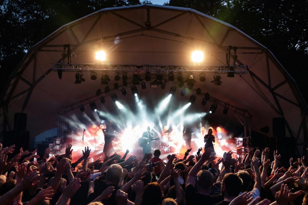 Vibrant live music performance at an outdoor festival with enthusiastic crowd.